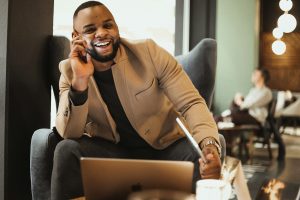 a man sitting in a chair talking on a cell phone