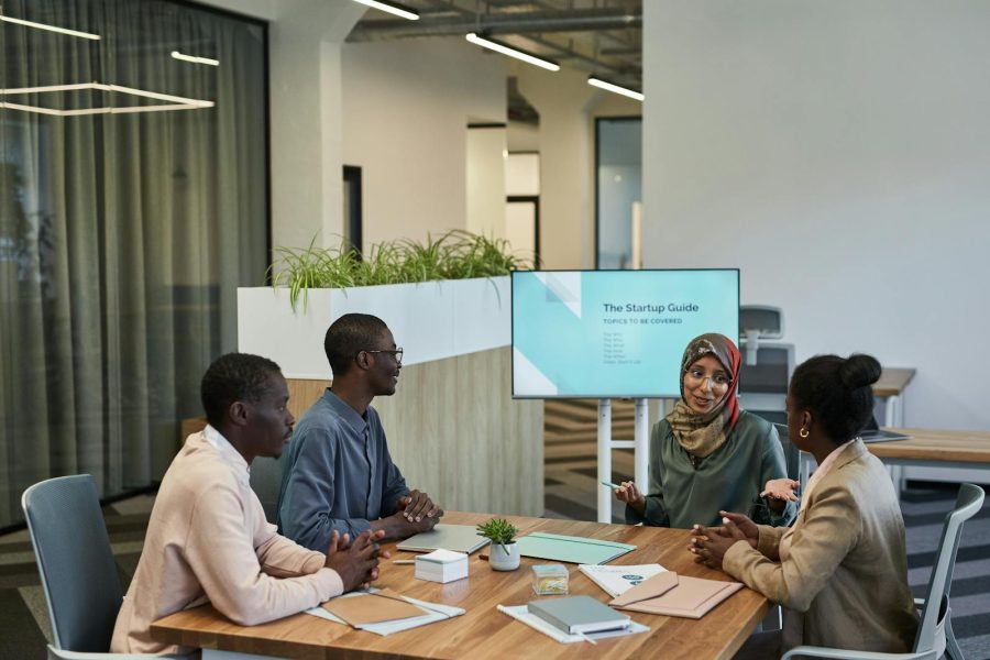 A diverse team discussing a startup guide in a modern office space, focusing on collaboration.